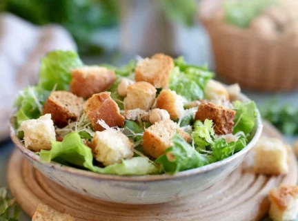 Croutons maison dans un bol de salade verte. Ambiance d'été.