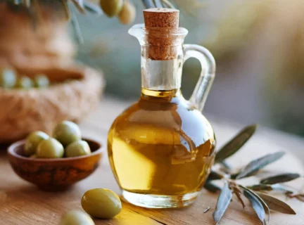 Bouteille d'huile d'olive placée sur une planche de bois. Ambiance d'été.